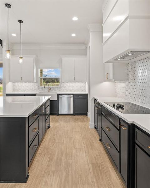 Dual tone kitchen with two tone color scheme, tasteful backsplash, light stone counters, hanging light fixtures, and crown molding