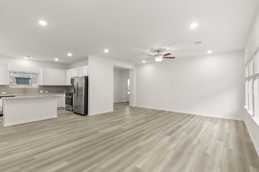 Open concept living space featuring light-toned flooring, recessed lighting, and a modern ceiling fan
