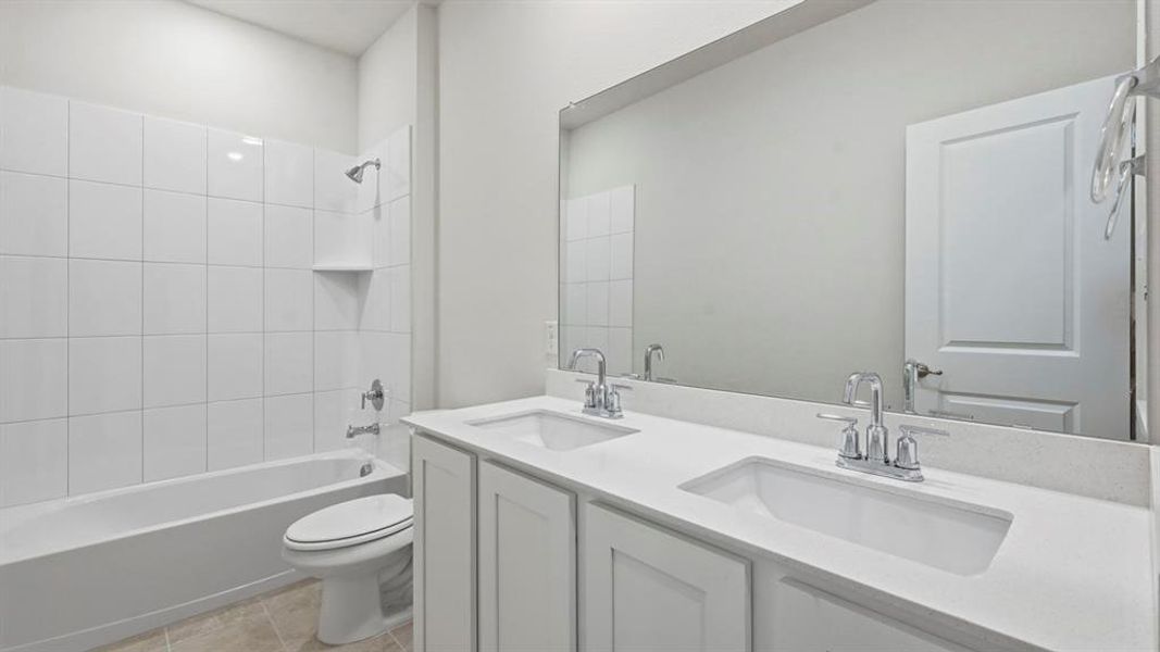 Bathroom featuring double vanity, shower combination, and light tile patterned flooring Bathroom featuring double vanity, shower combination, and light tile patterned flooring