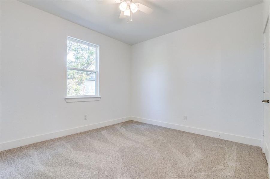 Carpeted empty room with ceiling fan