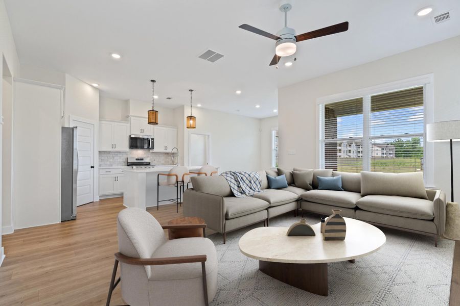 Open-concept living space featuring wood-finish flooring, recessed lighting, and a ceiling fan Open-concept living space featuring wood-finish flooring, recessed lighting, and a ceiling fan