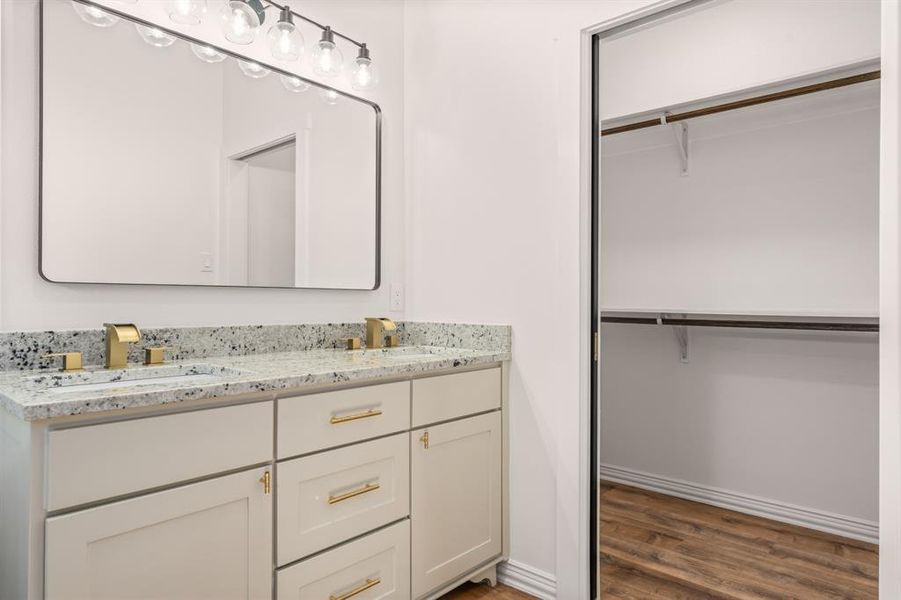 Primary bathroom with dual sinks, pocket door to walk in closet, and walk in tiled shower. Primary bathroom with dual sinks, pocket door to walk in closet, and walk in tiled shower.