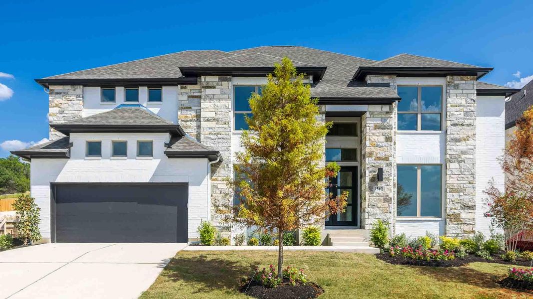 Prairie-style house with stone siding, driveway, a front lawn, and roof with shingles