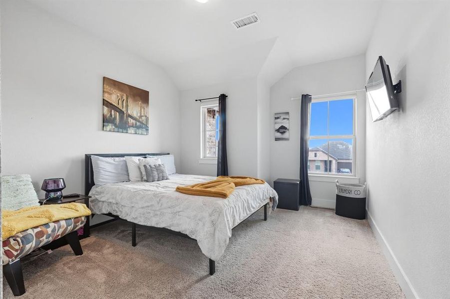 Bedroom featuring light colored carpet and lofted ceiling Bedroom featuring light colored carpet and lofted ceiling