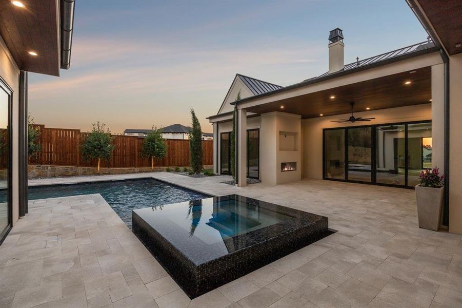 View of pool featuring a ceiling fan, a patio, a fenced backyard, and an in-ground hot tub View of pool featuring a ceiling fan, a patio, a fenced backyard, and an in-ground hot tub