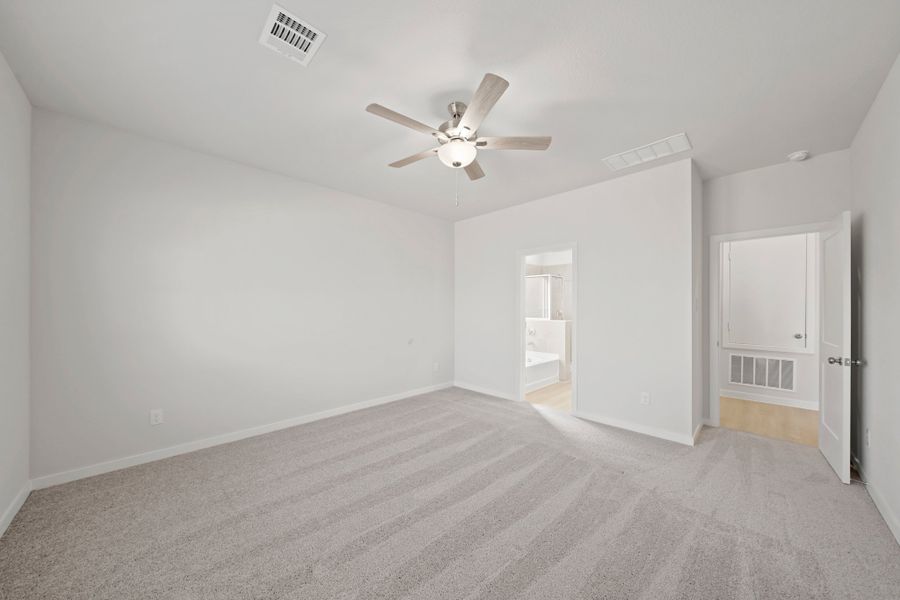 A room with a ceiling fan and a carpet. A room with a ceiling fan and a carpet.