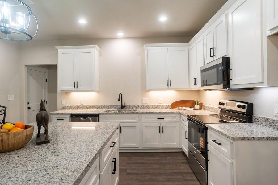 Kitchen featuring stainless steel appliances, a sink, white cabinets, dark wood-style floors, and recessed lighting Kitchen featuring stainless steel appliances, a sink, white cabinets, dark wood-style floors, and recessed lighting