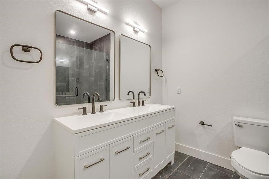 Full bath with double vanity and a stall shower
