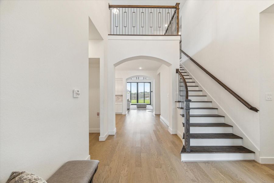 At the front of the two story foyer is the sweeping staircase with wood treads, modern wrought iron rails, and visually very appealing with all the arches. At the front of the two story foyer is the sweeping staircase with wood treads, modern wrought iron rails, and visually very appealing with all the arches.