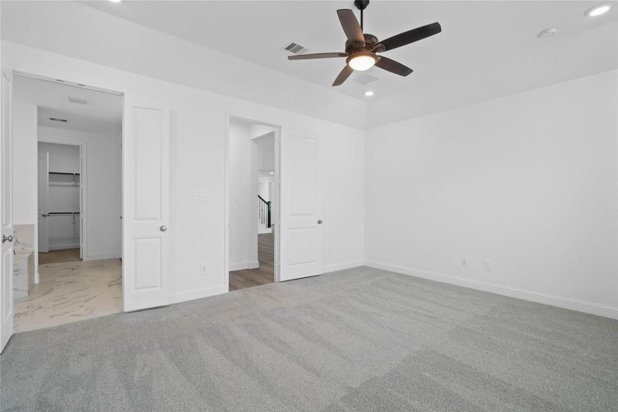 Additional view from primary bedroom looking towards the double door entrance to primary bathroom.