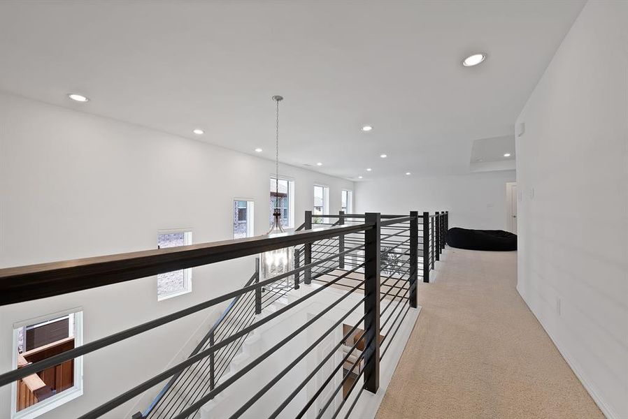 Upper-level landing featuring a contemporary metal railing system