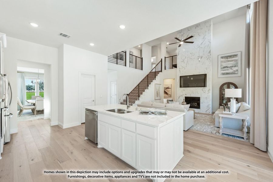 Open-concept kitchen with white island and quartz countertop, flowing into two-story living room with marble fireplace and staircase Open-concept kitchen with white island and quartz countertop, flowing into two-story living room with marble fireplace and staircase