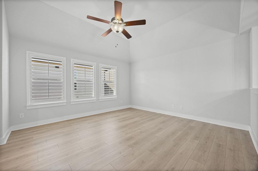 A tranquil primary bedroom with vaulted ceilings and abundant natural light.