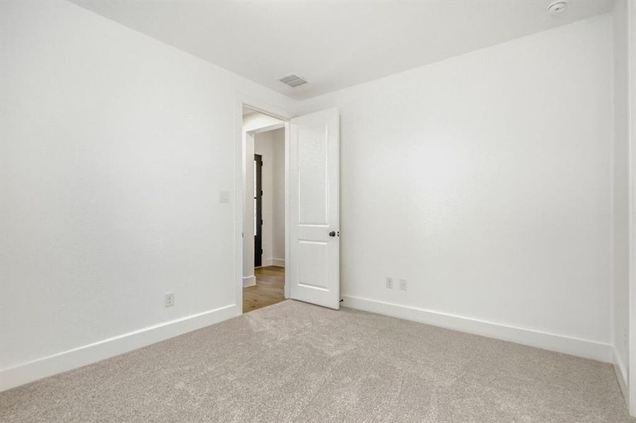 Empty room featuring light carpet and baseboards