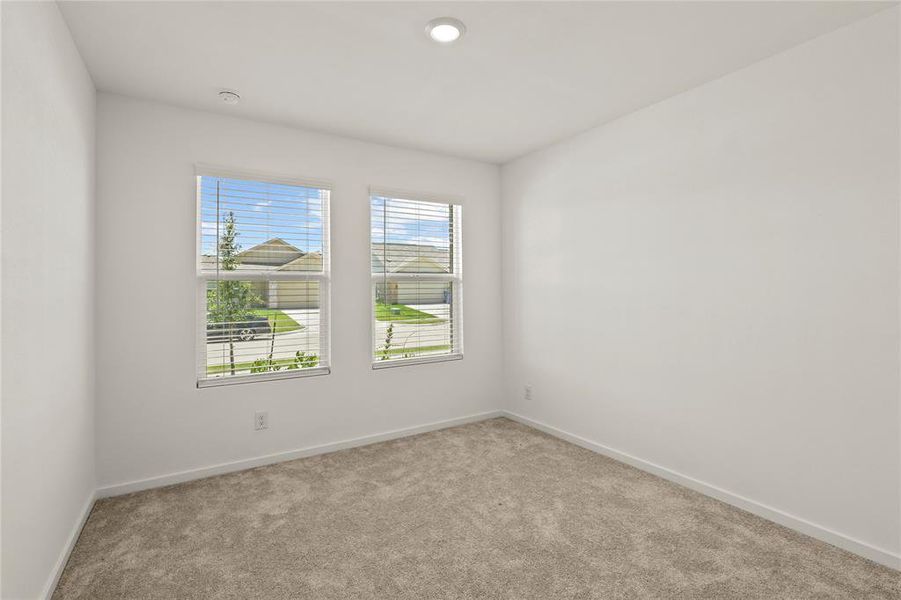 Bedroom with two windows featuring horizontal blinds