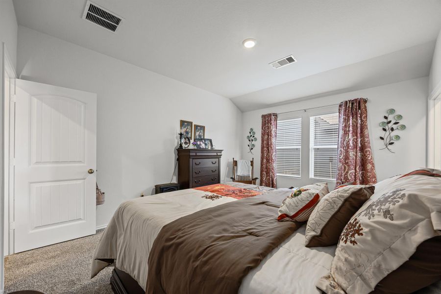Bedroom with carpet floors and lofted ceiling
