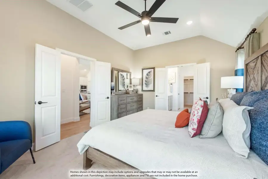 Master bedroom with vaulted ceiling, ceiling fan, barn door headboard, and walk-in closet entrance