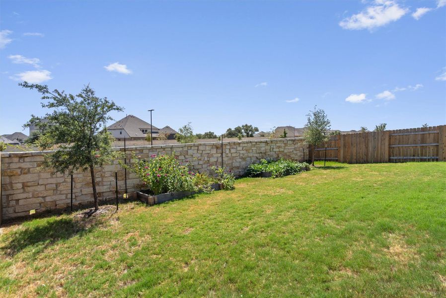 Stone and wood fencing borders a grassy lawn perfect for outdoor activities.