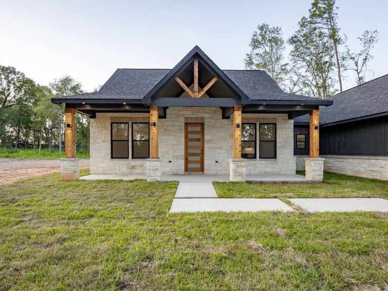 A symmetrical front porch anchored by exposed cedar columns and an eye-catching gable detail welcomes you home with warmth and sophistication. A symmetrical front porch anchored by exposed cedar columns and an eye-catching gable detail welcomes you home with warmth and sophistication.