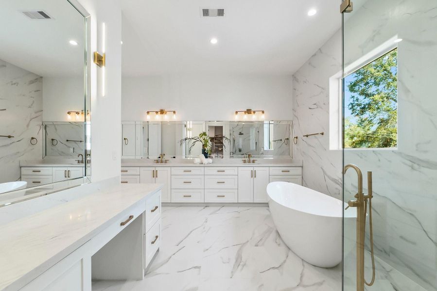 Luxurious spa-like primary bathroom with a freestanding soaking tub, dual vanities, a walk-in shower, and elegant finishes throughout.