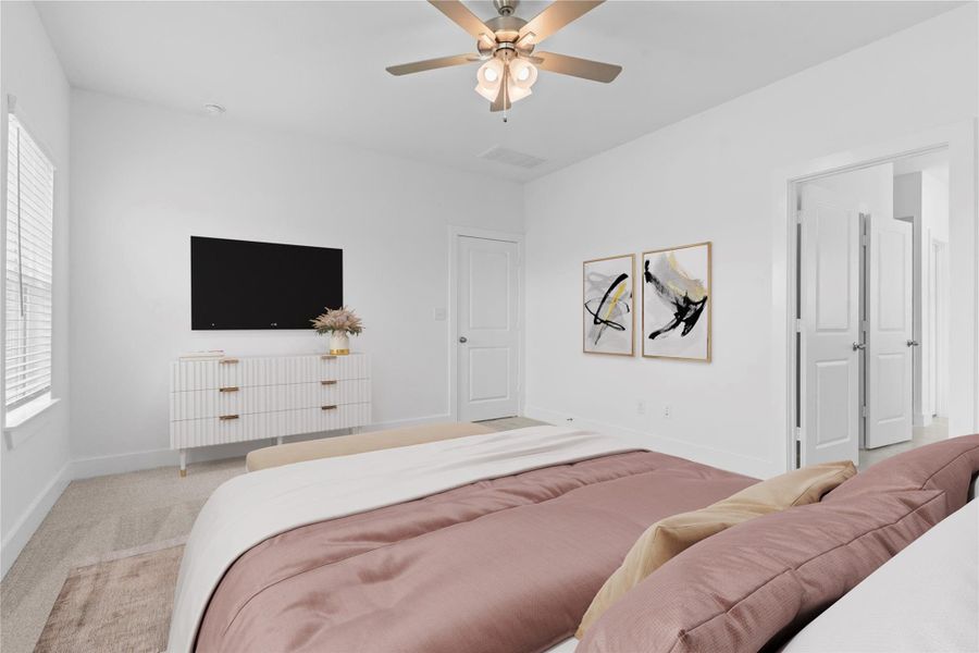 Another view of the private primary suite featuring high ceilings, plush carpet, and a spacious layout. Open the door to the luxurious en-suite bath, where comfort and style come together in your own personal retreat. *Virtually Staged* **Image Representative of Plan Only and May Vary as Built**.