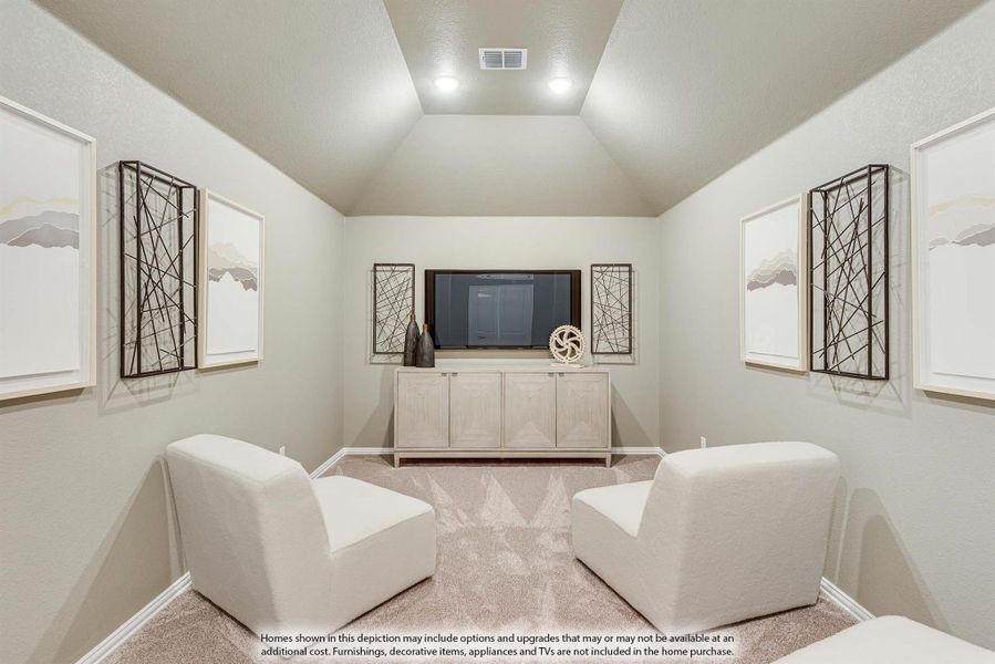 Media room with vaulted ceiling, wall-mounted TV, white credenza, and two white chairs on carpet