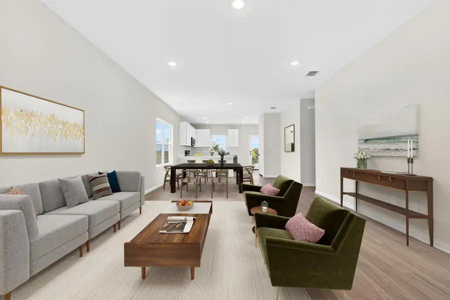 Recessed lighting and warm wood-style flooring flow through this open-concept main living area.