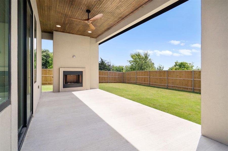 The property features an expansive outdoor patio with a fireplace and a wooden ceiling with a ceiling fan The property features an expansive outdoor patio with a fireplace and a wooden ceiling with a ceiling fan