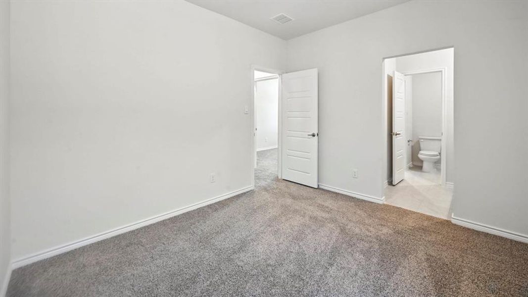 Unfurnished bedroom featuring light carpet and ensuite bathroom