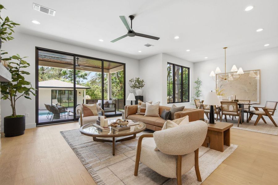 Smooth wood floors and recessed lighting anchor this open, airy living space.