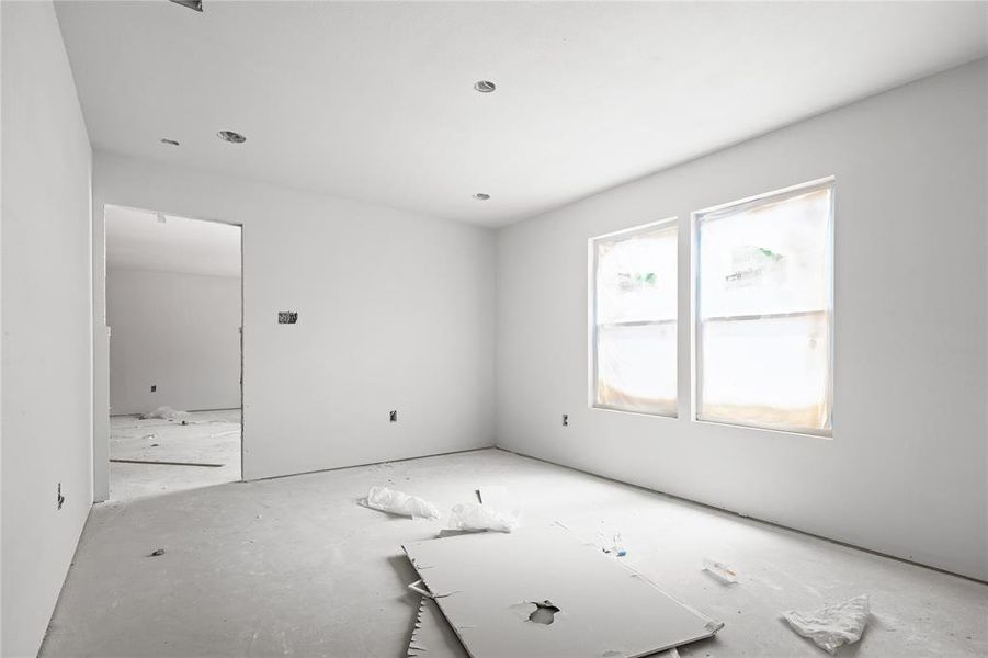 This property features an unfinished interior with white walls, two windows, and an open doorway