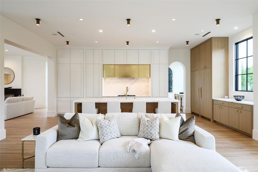 Living area with recessed lighting, arched walkways, and light wood-style floors Living area with recessed lighting, arched walkways, and light wood-style floors