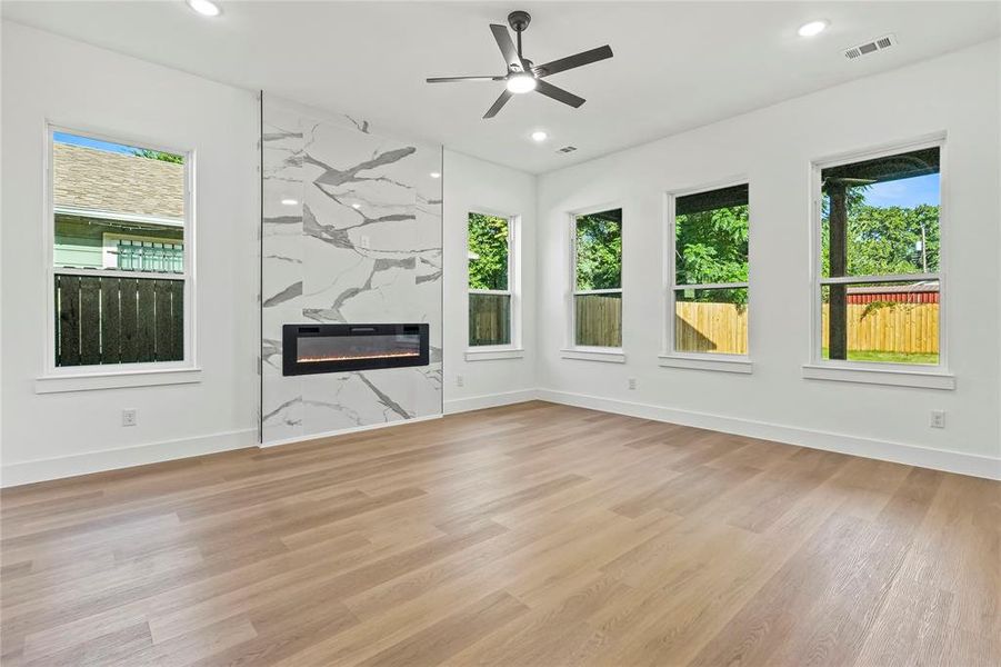 Unfurnished living room with a fireplace, light wood-style floors, ceiling fan, and recessed lighting