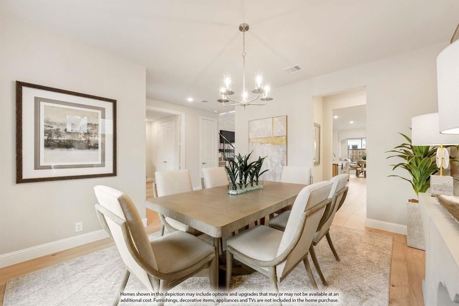 Formal dining room with wood table, six upholstered chairs, chandelier, and hardwood floors