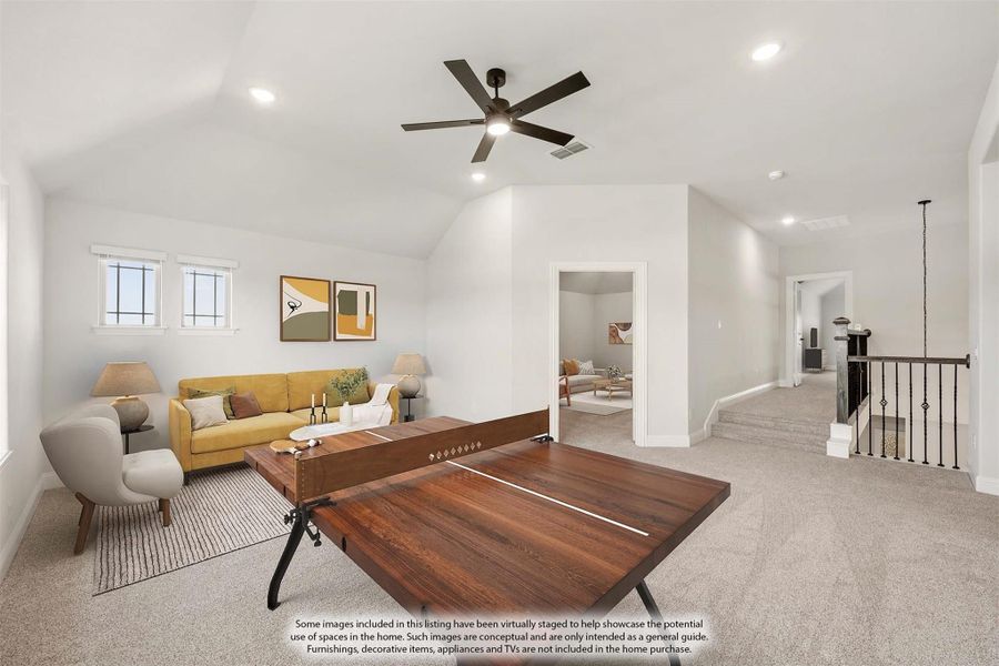 Upstairs bonus room with vaulted ceiling, carpet, ping pong table, and yellow sofa near staircase railing