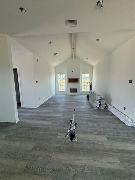 Unfurnished living room featuring vaulted ceiling with beams