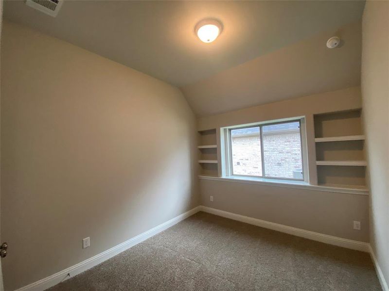 Bed 3 with built-in shelves, vaulted ceiling, and walk-in closet.