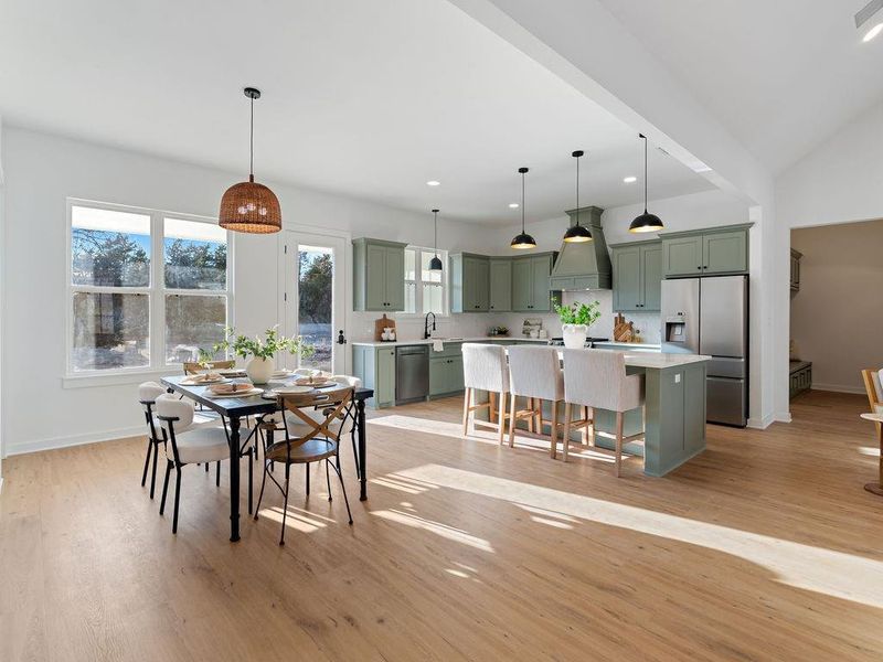Dining space featuring light wood finished floors, lofted ceiling, and recessed lighting