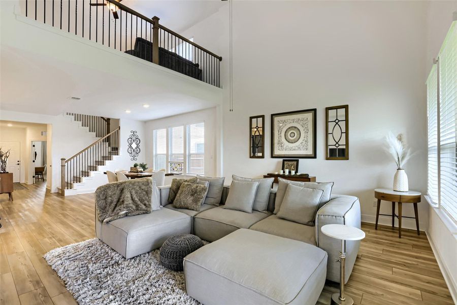 An inviting great room with soaring ceilings, a generous sitting area, and rich hardwood flooring flows seamlessly to an upper-level loft. An inviting great room with soaring ceilings, a generous sitting area, and rich hardwood flooring flows seamlessly to an upper-level loft.