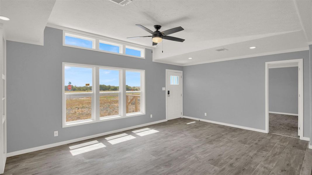 Ample natural light highlights the wood-look flooring and clean lines of this open living space.