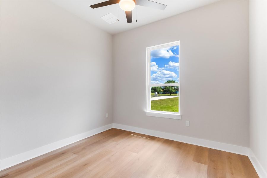 Spare room featuring light wood-style floors and ceiling fan