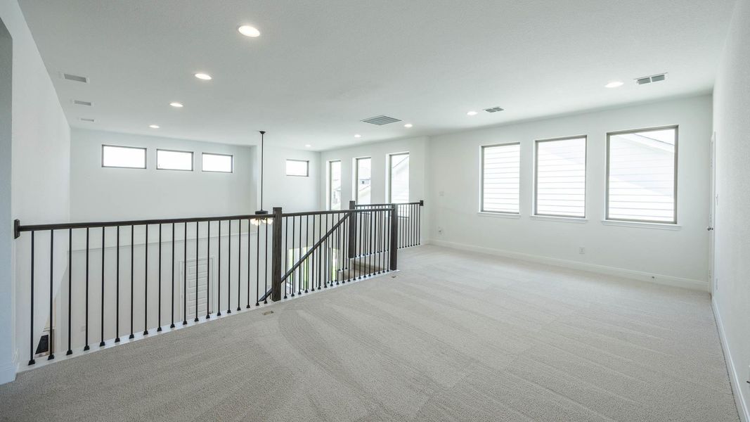Carpeted empty room featuring healthy amount of natural light and recessed lighting Carpeted empty room featuring healthy amount of natural light and recessed lighting