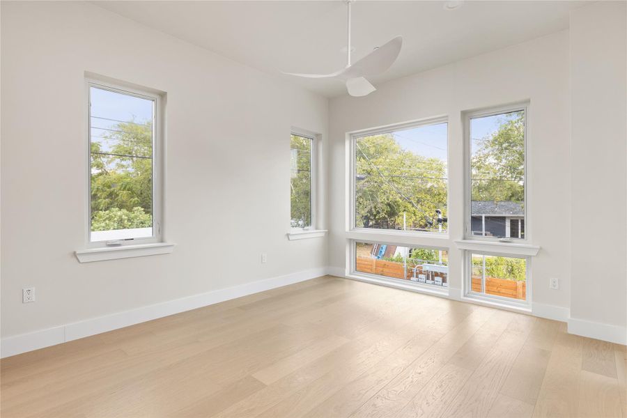 Gleaming hardwood floors and multiple large windows define this airy, sun-drenched space.