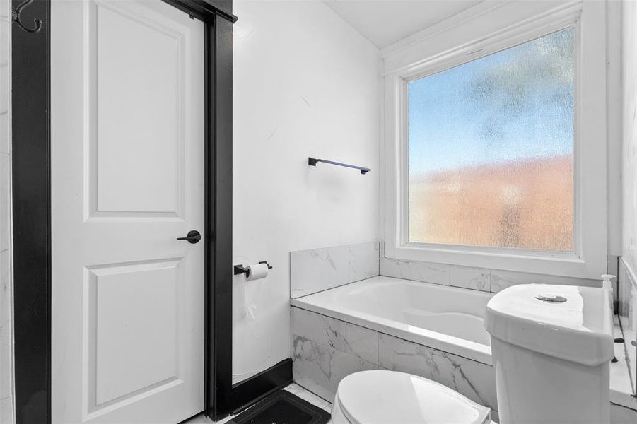 Full bathroom with a bath and toilet Full bathroom with a bath and toilet