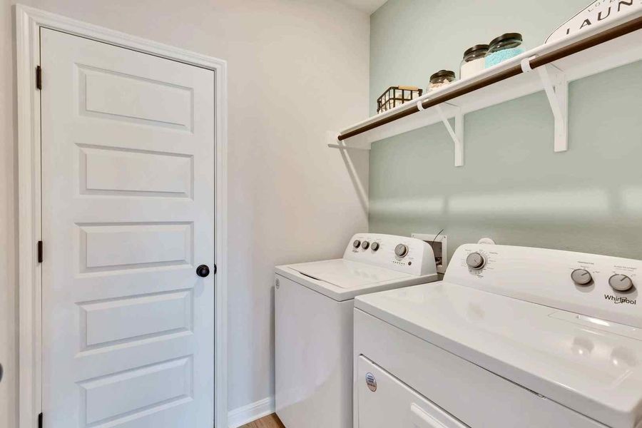 Functional utility space with convenient wall-mounted shelving above the laundry appliances. Functional utility space with convenient wall-mounted shelving above the laundry appliances.
