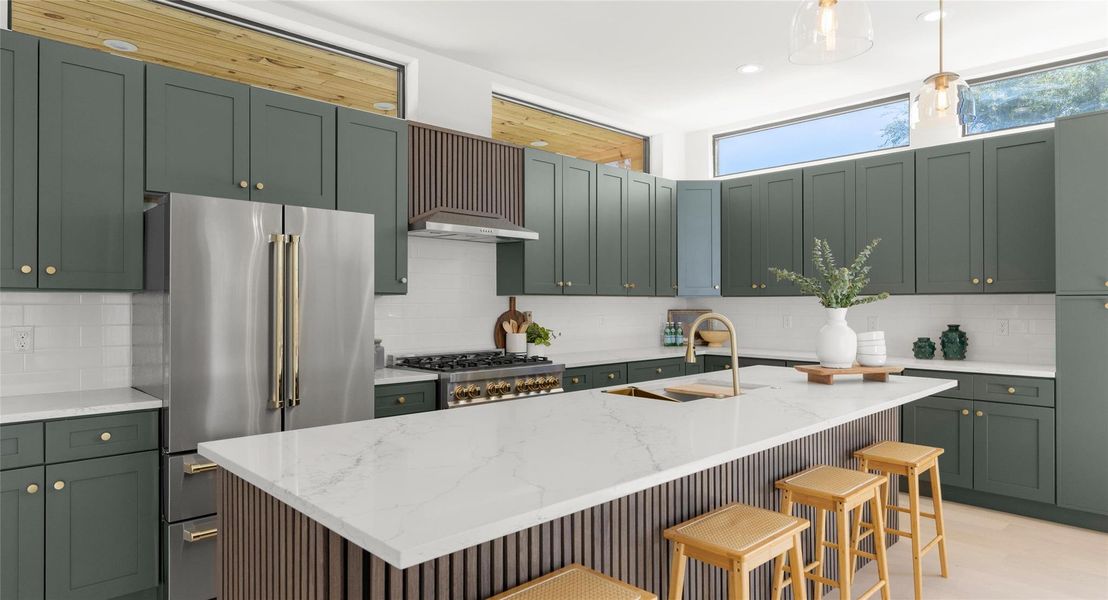 Kitchen with green cabinetry, stainless steel appliances, light stone countertops, and tasteful backsplash