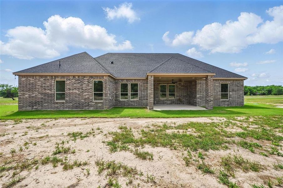 Back of property featuring a patio area, brick siding, roof with shingles, and a yard Back of property featuring a patio area, brick siding, roof with shingles, and a yard