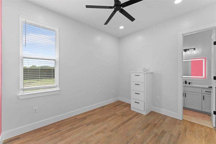 Unfurnished bedroom with light wood-style floors, ceiling fan, recessed lighting, and ensuite bath Unfurnished bedroom with light wood-style floors, ceiling fan, recessed lighting, and ensuite bath