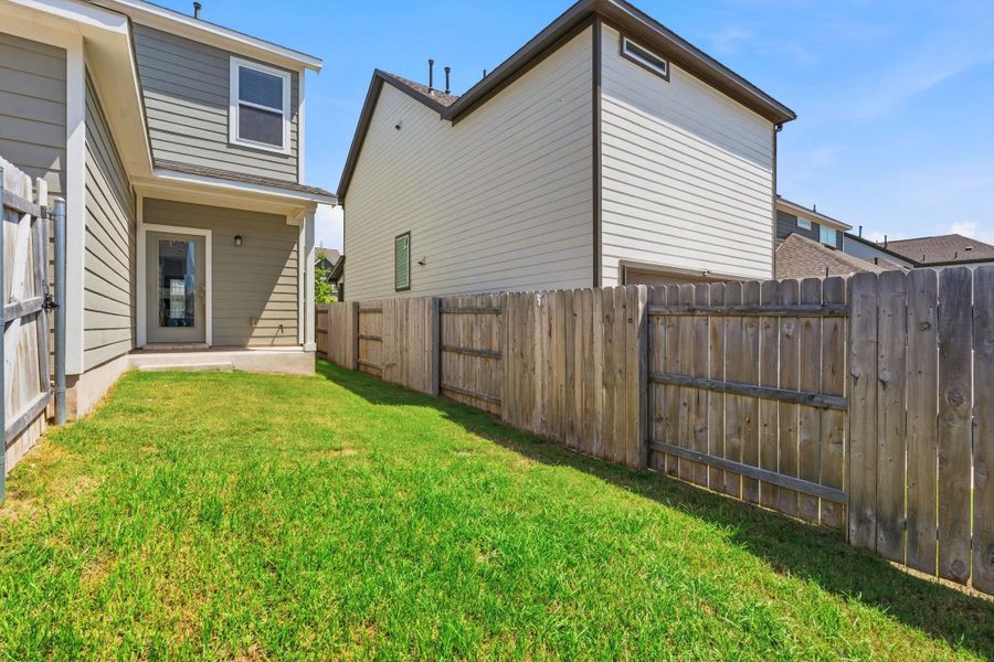 A neatly fenced private yard with vibrant green grass offers a secluded outdoor retreat. A neatly fenced private yard with vibrant green grass offers a secluded outdoor retreat.