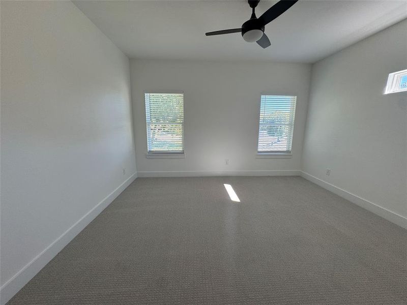 Unfurnished room with ceiling fan and carpet flooring